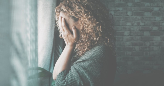 Sad woman with her hand on her head as she recovers after a medical malpractice incident.