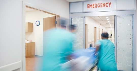 Doctors rushing into an emergency room with a patient.